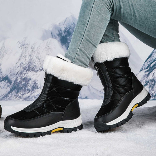 Black winter boots with white fur lining worn by a person in a snowy landscape.