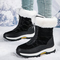 Black winter boots with white fur lining worn in the snow